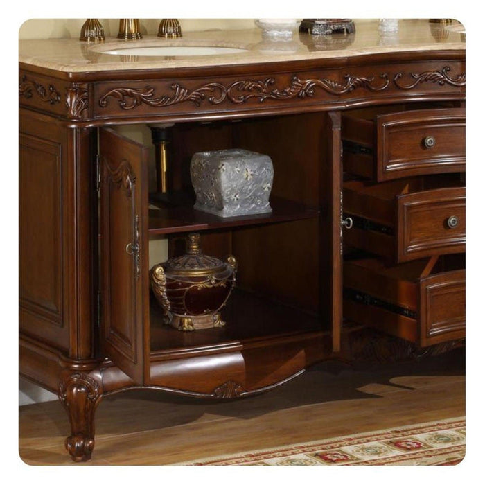 Ornate wooden vanity with marble top, carved details, open shelving with decorative urns, and curved cabriole legs on patterned floor.