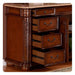 Dark wood dresser with three open drawers, ornate carved side column, and decorative metal drawer pulls.