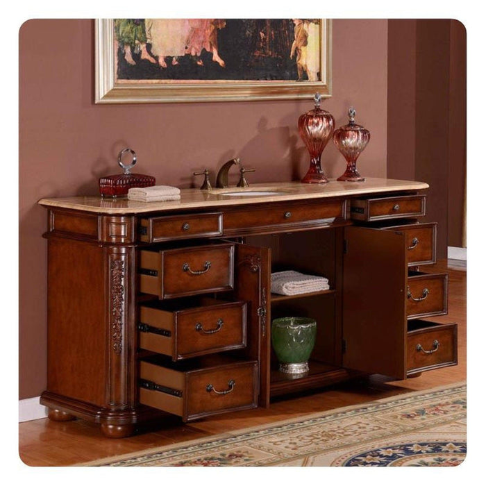 Ornate wooden vanity with marble top, multiple drawers open, displaying decorative red glass urns and green vase against dusty rose wall.