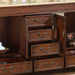 Rich wood dresser with multiple open drawers, antique bronze pulls, and decorative ornament visible on side shelf.
