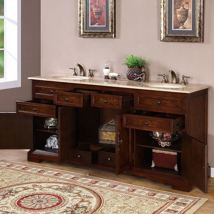 Rich wood bathroom vanity with double sinks, marble top, ornate framed art, and decorative storage shelves with accessories.