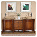Elegant wooden bathroom vanity with two vessel sinks, white flower vase, and abstract framed art in silver frames.