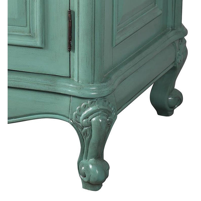 Vintage seafoam green cabinet with ornate curved legs and decorative hinged door, showing distressed paint finish.
