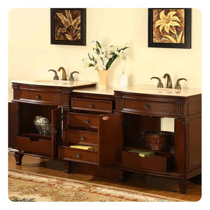 Elegant wooden bathroom vanity with double sinks, white marble top, bronze faucets, and decorative floral artwork above white lilies.