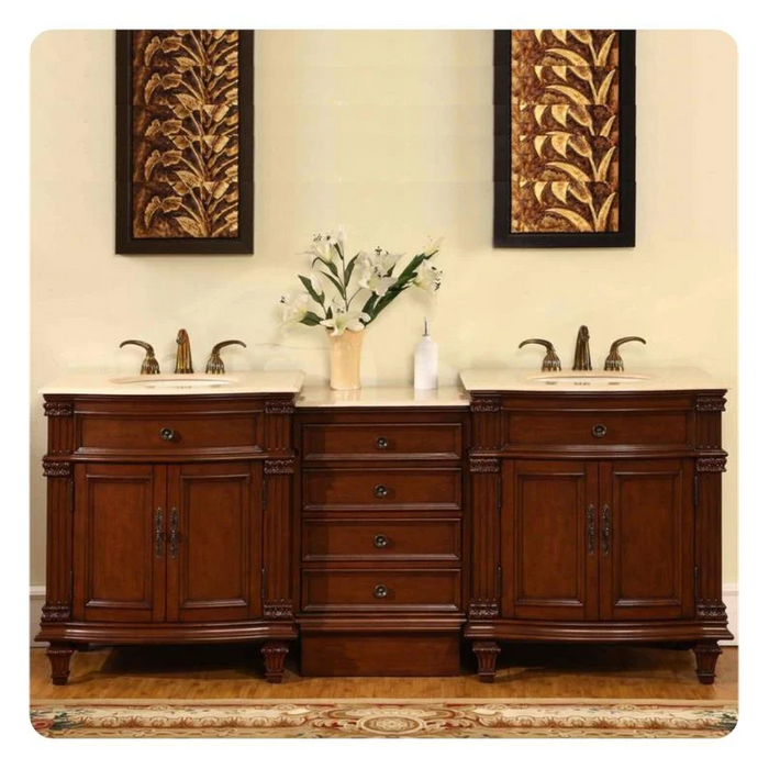 Elegant wooden bathroom vanity with double sinks, ornate brown cabinets, white marble top, and floral wall art above