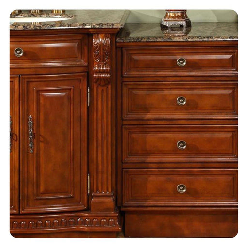 Rich cherry wood kitchen cabinetry with ornate carved details, marble countertop, and decorative bronze hardware