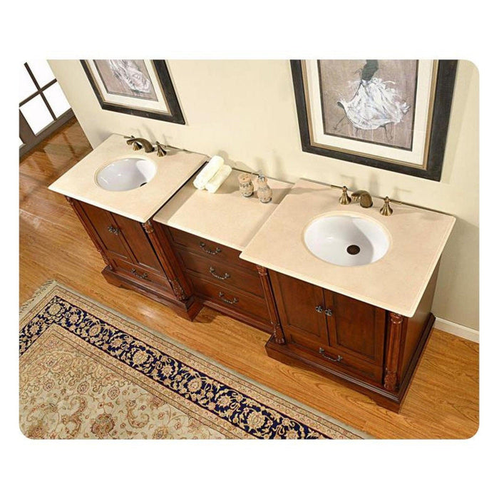 Dark wood double vanity with cream marble countertop, two white sinks, and decorative artwork on beige wall.