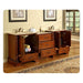 Vintage wooden bathroom vanity with double sinks, marble countertop, open cabinet doors revealing towel storage and drawers, with framed art and window in background.