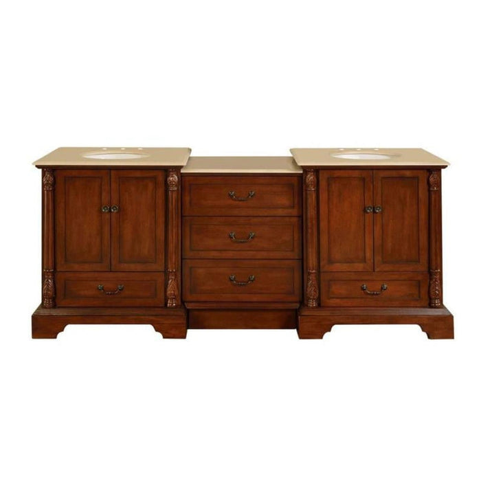 Traditional wooden bathroom vanity with rich brown finish, two sinks, and ornate carved columns flanking three center drawers.
