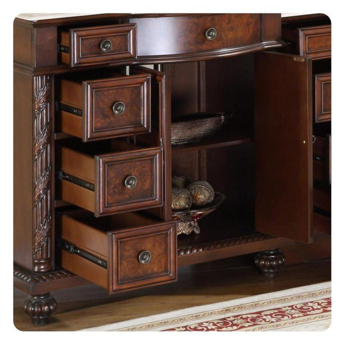 Rich wooden furniture piece with ornate carved details, multiple drawers, and decorative turned feet, partially open to reveal interior shelf and ornamental object.