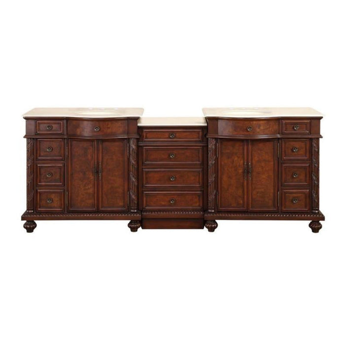 Antique wooden double vanity with rich brown finish, marble top, ornate drawers, and decorative column details between two cabinets.