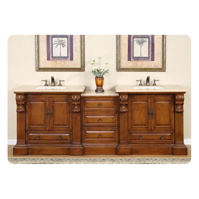 Elegant wooden double vanity with two sinks, ornate carved details, marble countertop, and palm tree artwork above.