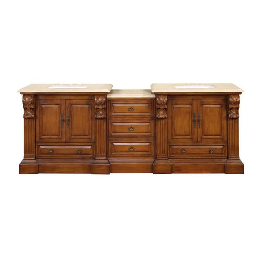 Ornate wooden bathroom vanity with three sections, carved columns, cream marble top, and multiple drawers and cabinets.