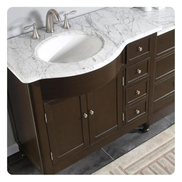 Dark brown bathroom vanity with white marble countertop and oval undermount sink, featuring brushed nickel faucet and cabinet hardware.