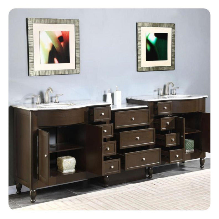 Dark wood bathroom vanity with marble top, two sinks, and multiple drawers, accented by abstract framed art in textured frames.