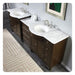 Dark wood double vanity with white marble countertop and two oval sinks, silver faucets, and decorative patterned area rug.