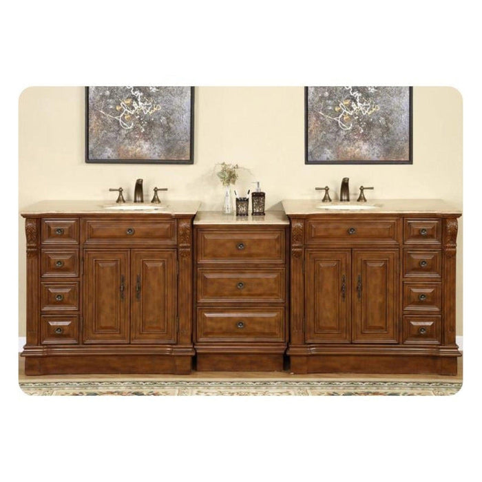 Elegant wooden double bathroom vanity with rich brown finish, two sinks, decorative artwork, and center drawers on patterned rug.