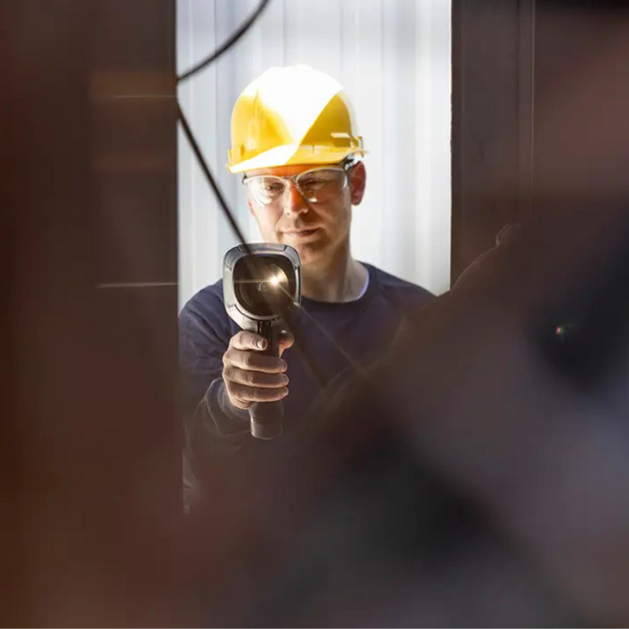 Teledyne FLIR E5 Pro person using camera inspection hard hat.