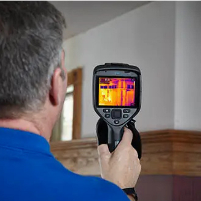 Teledyne FLIR E54 24 NIST man using camera back view thermal screen visible.