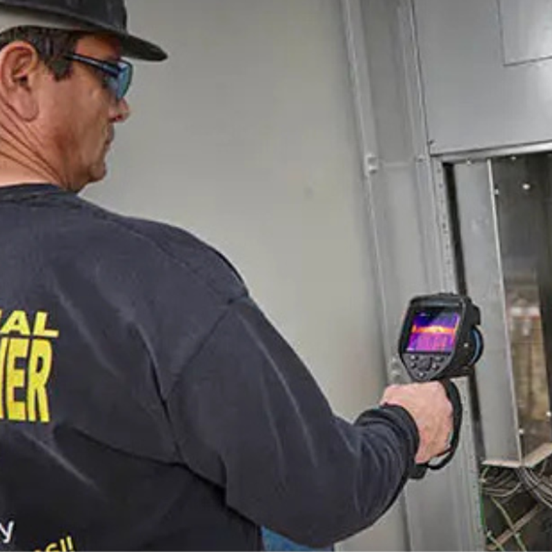 Teledyne FLIR E76 24 14 Advanced Thermal Imaging Camera inspector using thermal camera on wall panel.