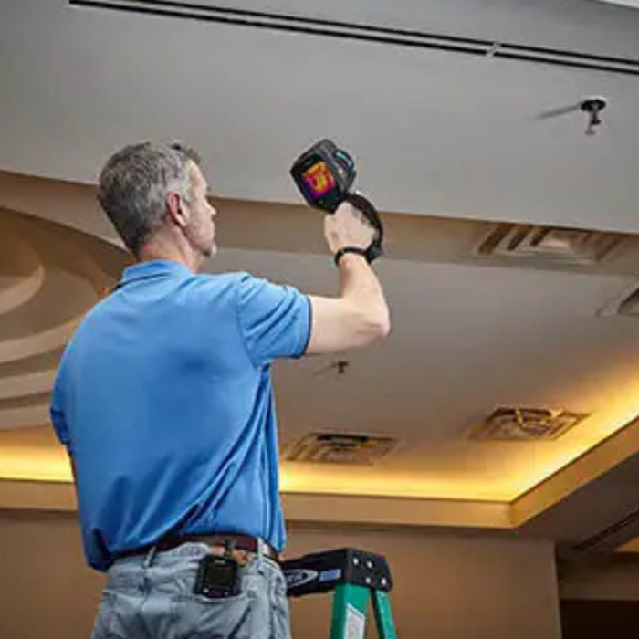 Teledyne FLIR E86 24 14 person using thermal camera to scan ceiling.