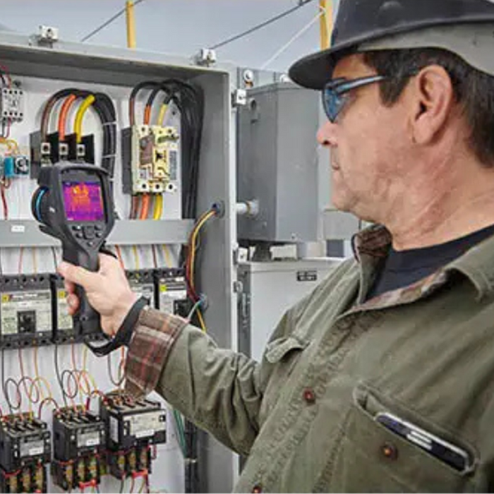 Teledyne FLIR E86 24 14 technician using camera to inspect electrical panel.