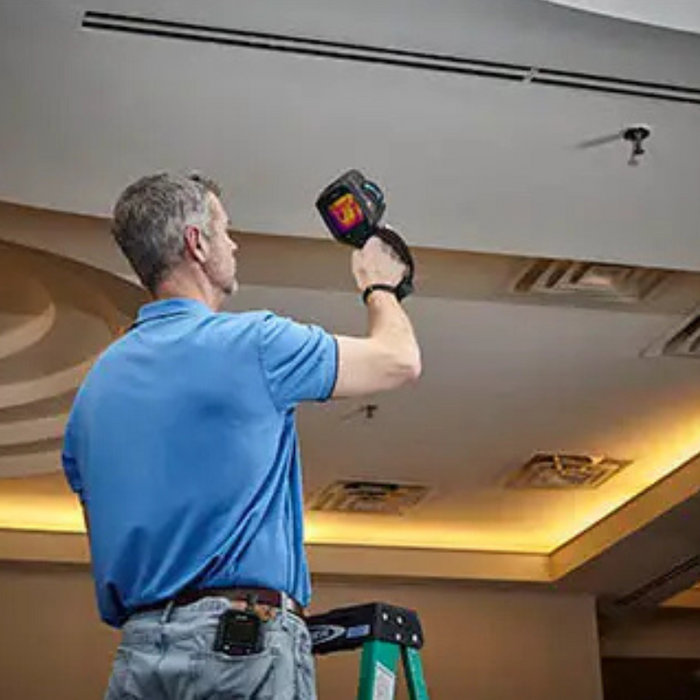 Teledyne FLIR E86 Dual FOV 24 42 man in blue shirt using thermal camera to inspect ceiling.