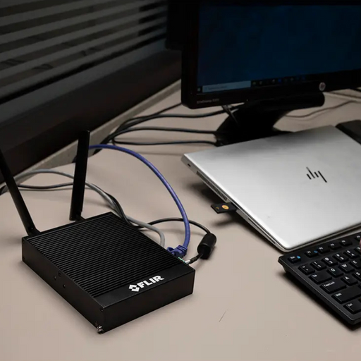 Teledyne FLIR GW66 Remote Monitoring Gateway connected to laptop on office desk.
