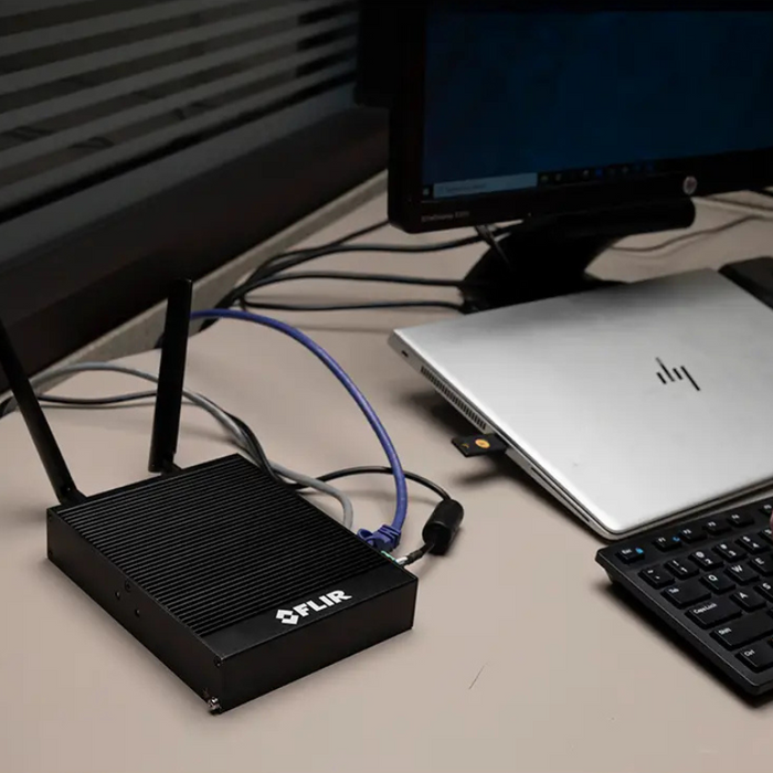 Teledyne FLIR GW66 Remote Monitoring Gateway connected to laptop on office desk.