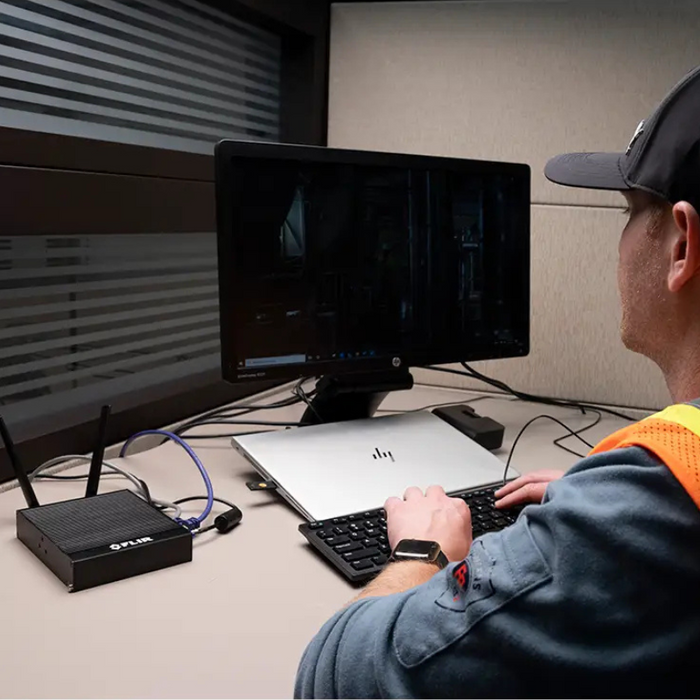 Teledyne FLIR GW66 Remote Monitoring Gateway person operating computer connected to gateway.