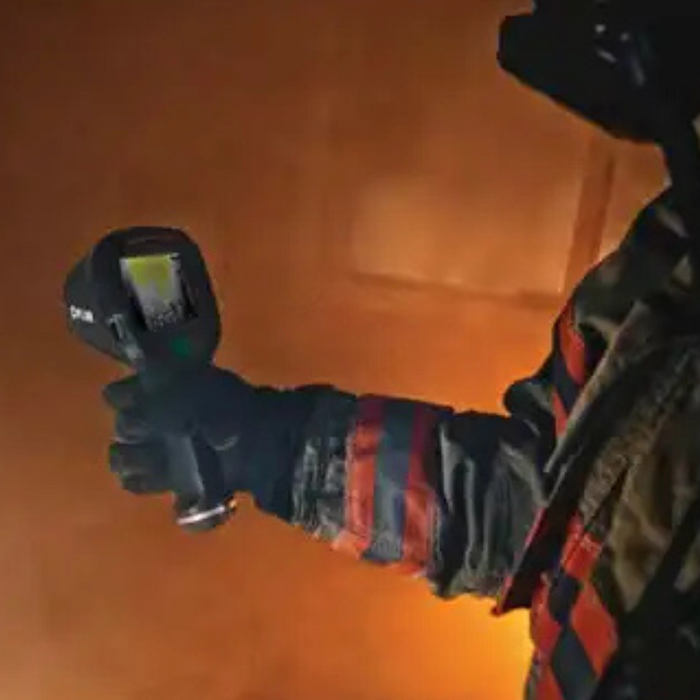 Teledyne FLIR K33 firefighter using camera in smoke filled room.