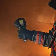 Teledyne FLIR K53 firefighter holding thermal camera in smoke filled environment.