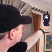 Teledyne FLIR MR176 Imaging Moisture Meter Plus with IGM Technology and Lepton Image Detector-person using device on curtain.