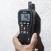 Teledyne FLIR MR77 5 In 1 Moisture Meter hand holding device measuring wall.