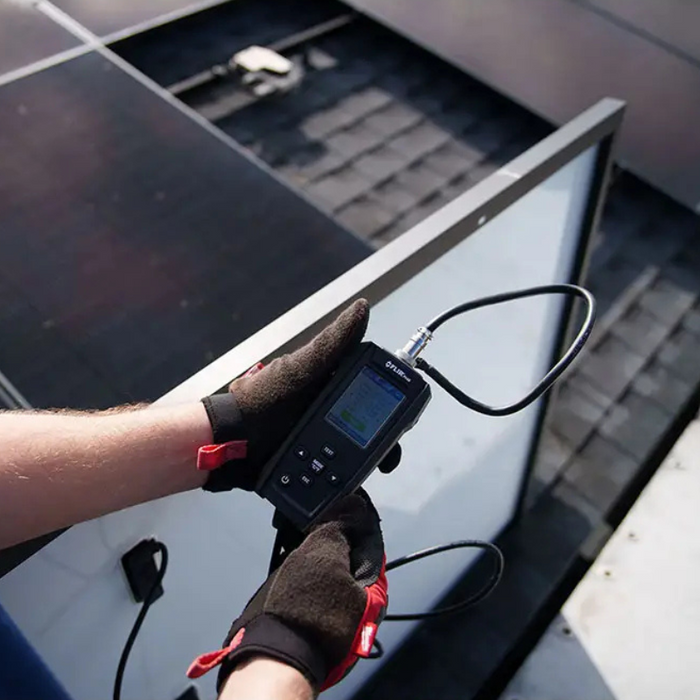 Teledyne FLIR PV48 user holding device outdoor solar panel testing.