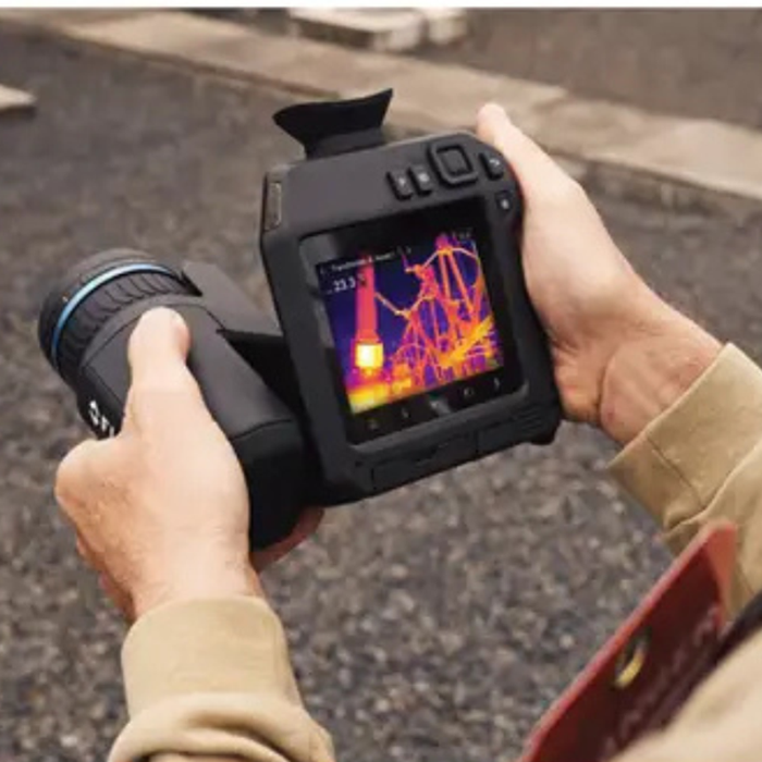 Teledyne FLIR T865 24 14 angled view hands holding camera screen showing thermal reading.