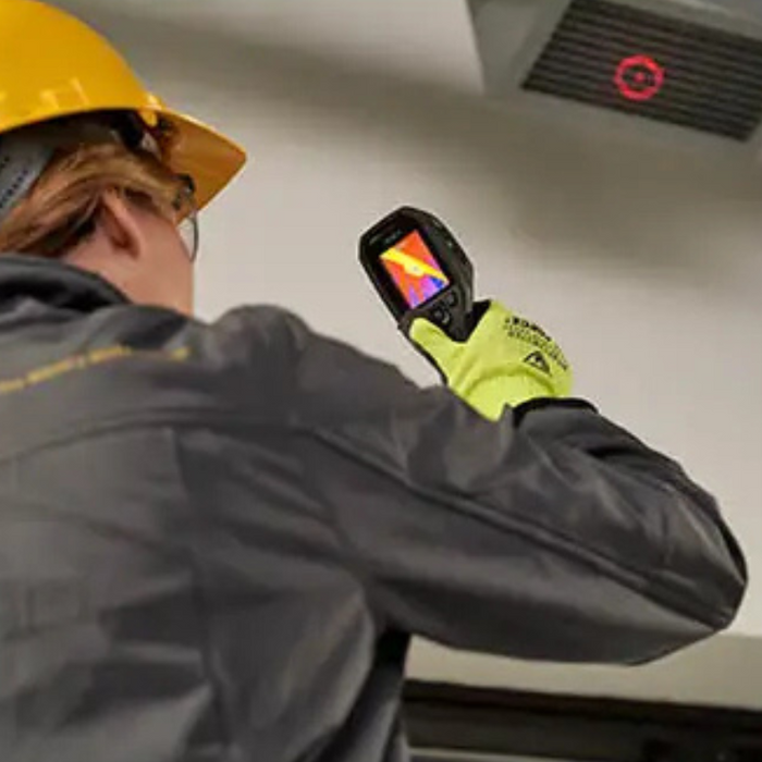Teledyne FLIR TG165 X technician aiming at ceiling vent thermal scan.