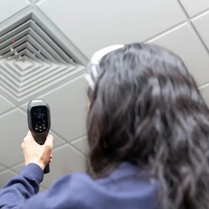 Teledyne FLIR TG54 2 spot thermometer person aiming at ceiling vent.