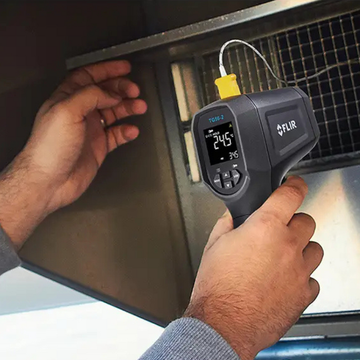 Teledyne FLIR TG56 2 in use hand holding device pointing at metal surface.