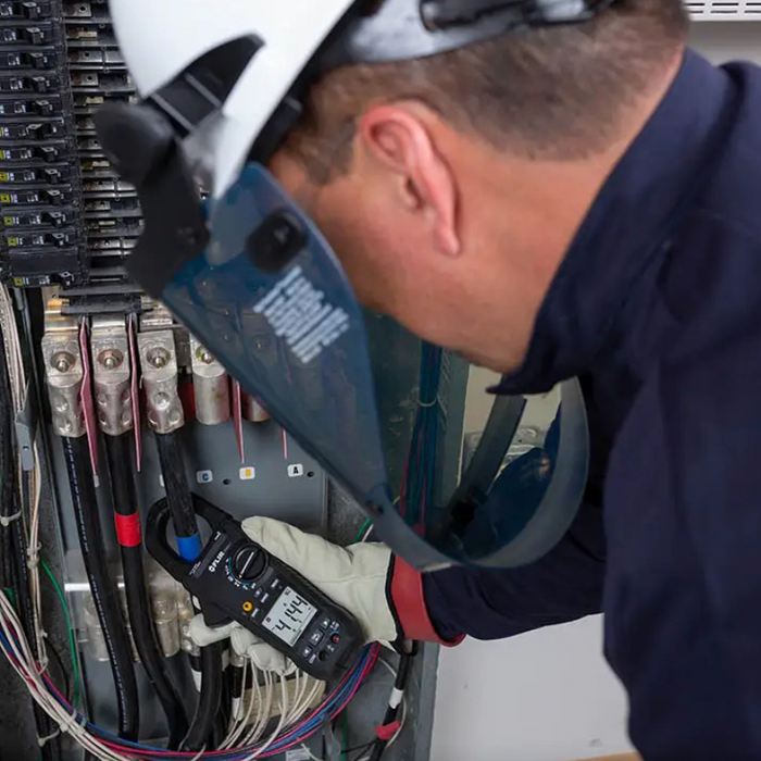 Teledyne Flir Cm85 2 technician using meter in panel protective gear.