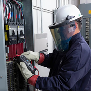 Teledyne Flir Dm286 electrician using multimeter on breaker panel full safety gear.