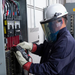 Teledyne Flir Dm286 electrician using multimeter on breaker panel full safety gear.