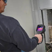 Teledyne Flir E76 24 14 42 Nist technician using thermal camera on electrical panel.