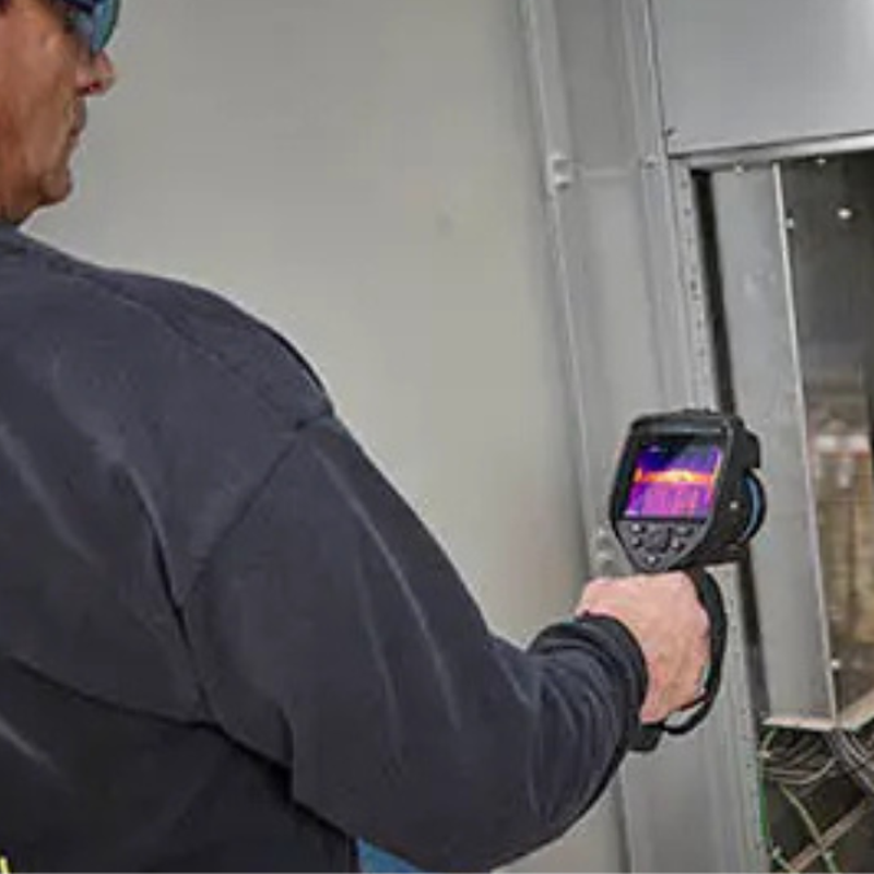 Teledyne Flir E76 24 Nist technician scanning electrical panel with thermal camera.