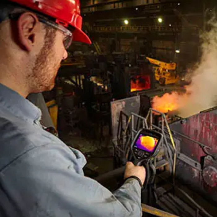 Teledyne Flir E76 dual fov worker using thermal camera in industrial setting.