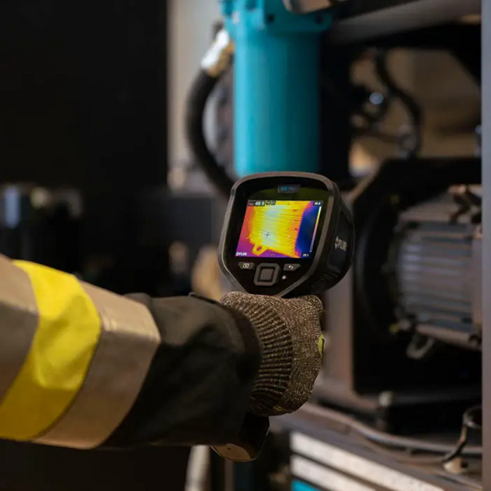 Teledyne Flir E8 Pro Nist person using thermal camera on industrial machinery.