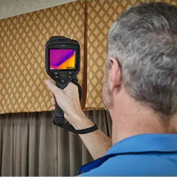 Teledyne Flir E86 24 14 42 Nist person using camera on curtains detecting temperature difference.