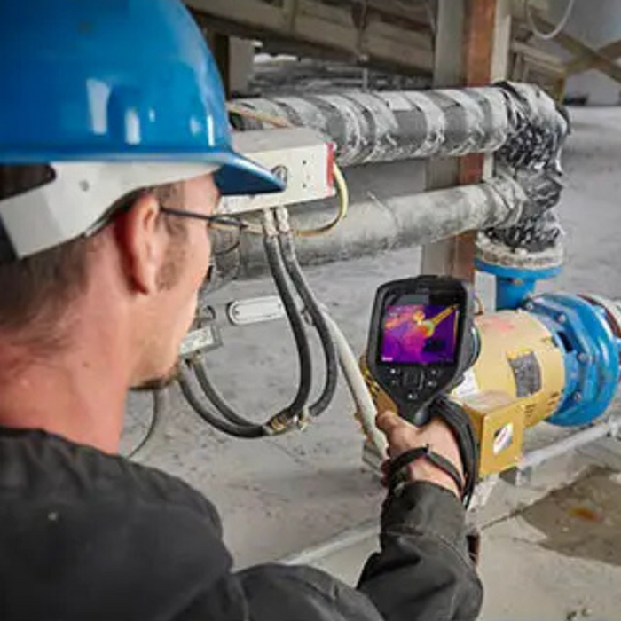 Teledyne Flir E96 24 Nist worker using camera on industrial piping.