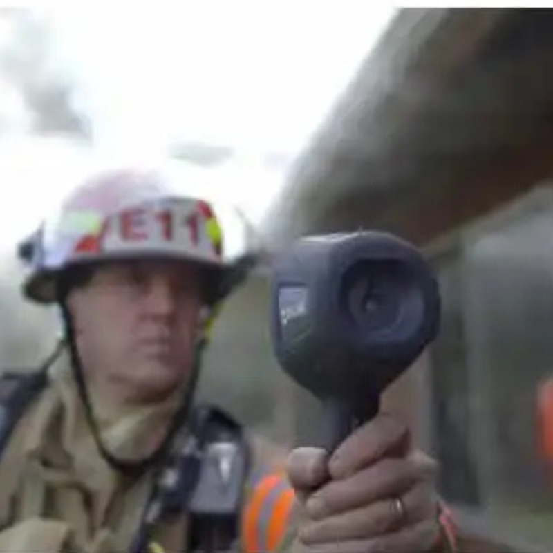 Teledyne Flir K65 firefighter holding thermal camera front view.