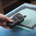 Teledyne Flir Mr176 Kit5 hand holding device over honeycomb surface.